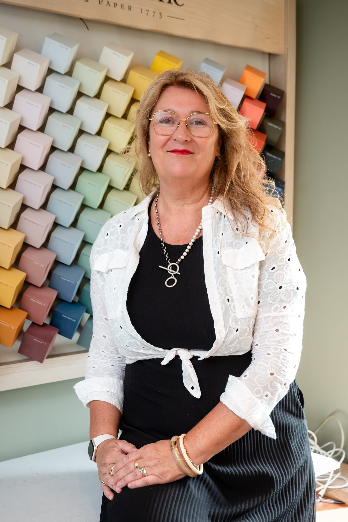 Myriam Blin, décoratrice et coloriste, devant le mur de nuancier Little Greene